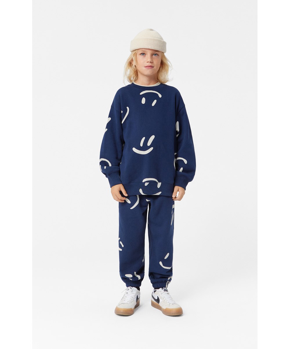 Monti - Big Smiles Navy - Donkerblauwe biologisch katoenen sweater met witte smileyprint.