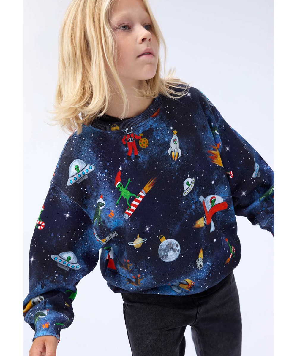 Monti - Space Holiday - Blauwe kindersweater gemaakt van zacht biologisch katoen met een print van kerstmis in de ruimte.