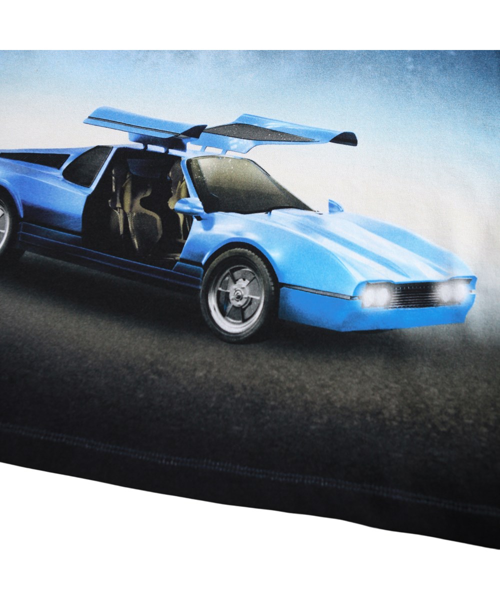 Reif - Blue Car - Donkerblauwe longsleeve voor kinderen gemaakt van zacht biologisch katoen met een ribboord rond de hals. De longsleeve heeft een ruimvallende pasvorm en een print op de voorkant van een blauwe sportwagen onder een sterrenhemel.