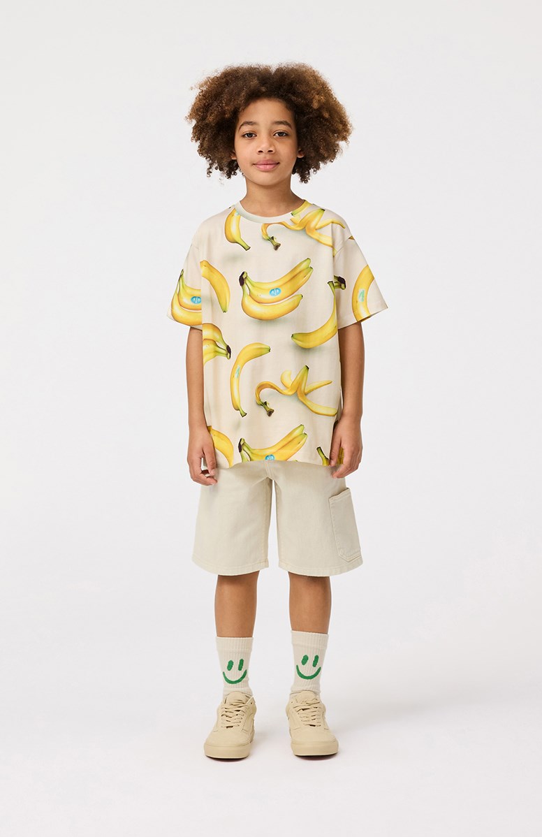 Riley - Bananas - Beige kinder t-shirt met print  in zacht biologisch katoen met korte mouwen en ribboord rond de hals.