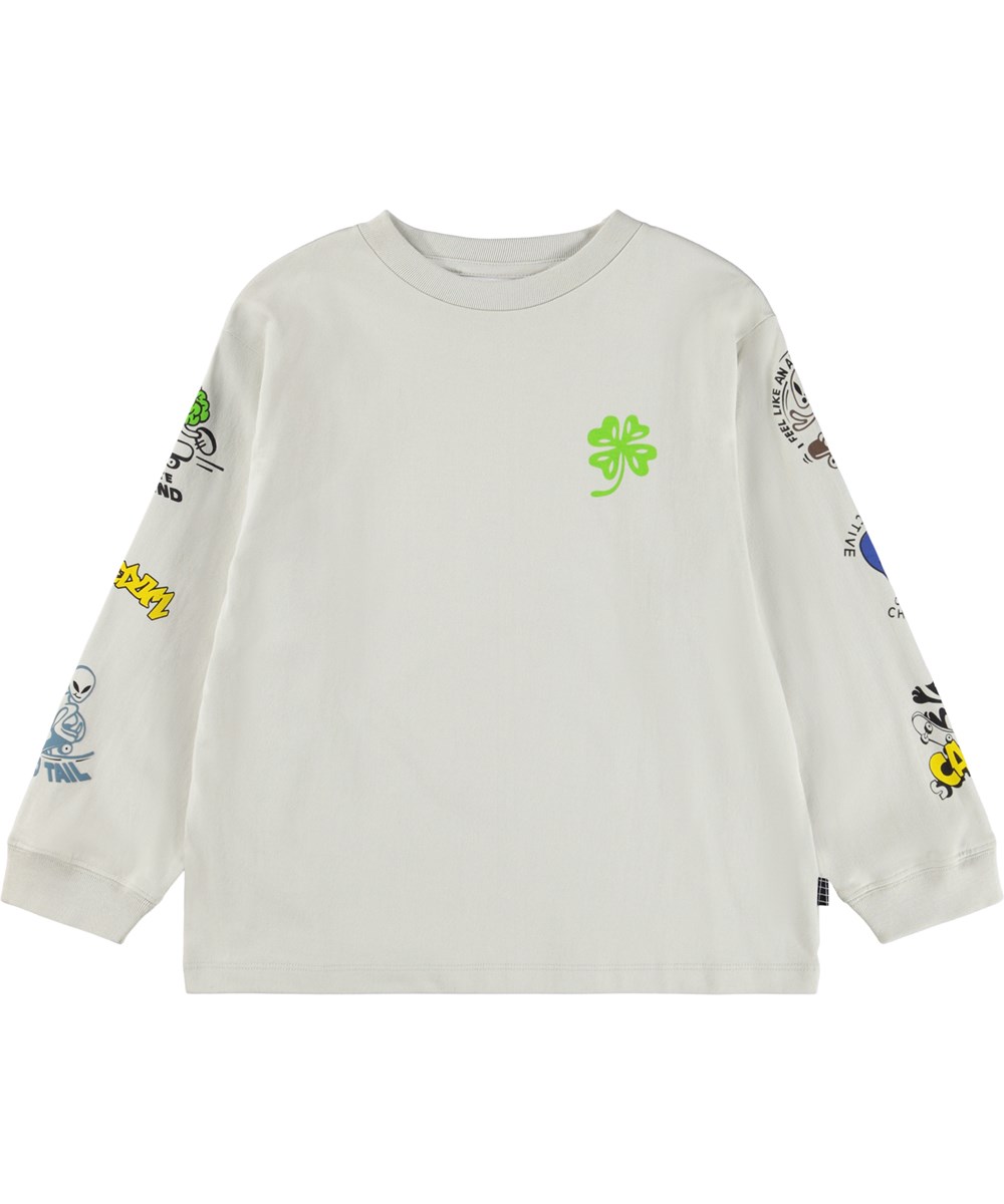 Rube - Comic Skate - Beige longsleeve voor kinderen gemaakt van biologisch katoen met een ribboord rond de hals en mouwen met een print van aliens en katten op skateboards evenals leuke en schattige uitspraken langs de mouwen.