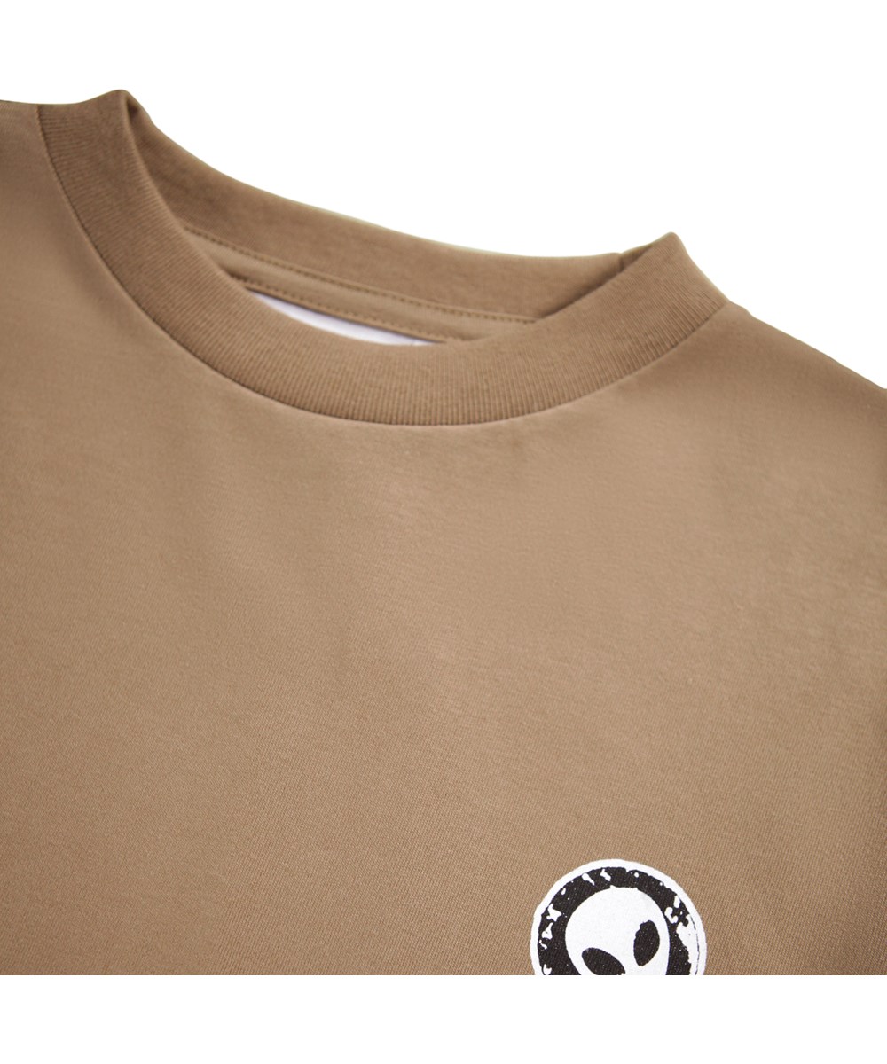 Rube - Fawn - Bruine longsleeve voor kinderen gemaakt van biologisch katoen met een ribboord rond de hals en mouwen met kleine zwart-witte prints van stickers met grappige en schattige uitspraken.