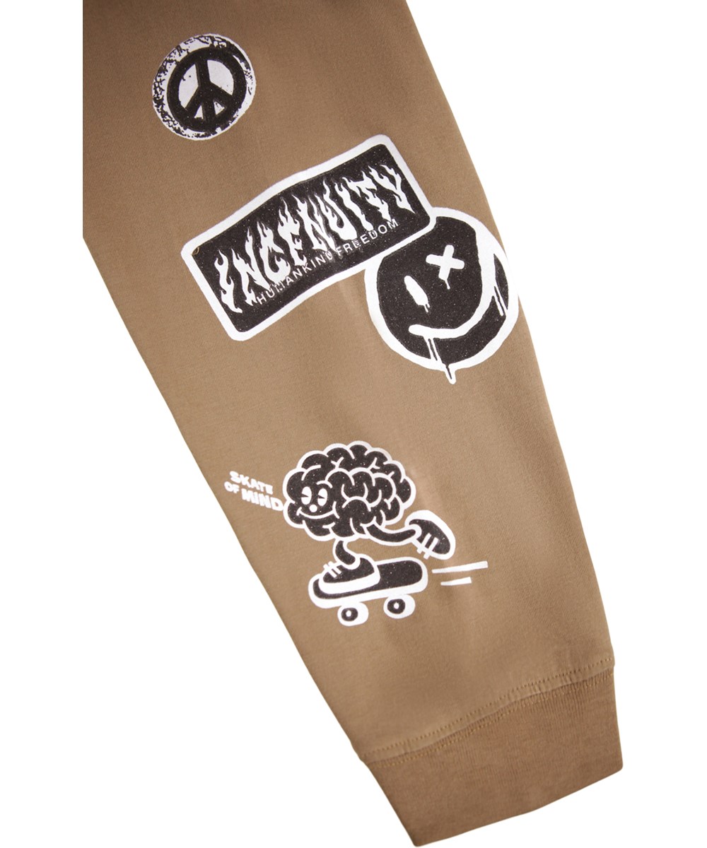 Rube - Fawn - Bruine longsleeve voor kinderen gemaakt van biologisch katoen met een ribboord rond de hals en mouwen met kleine zwart-witte prints van stickers met grappige en schattige uitspraken.