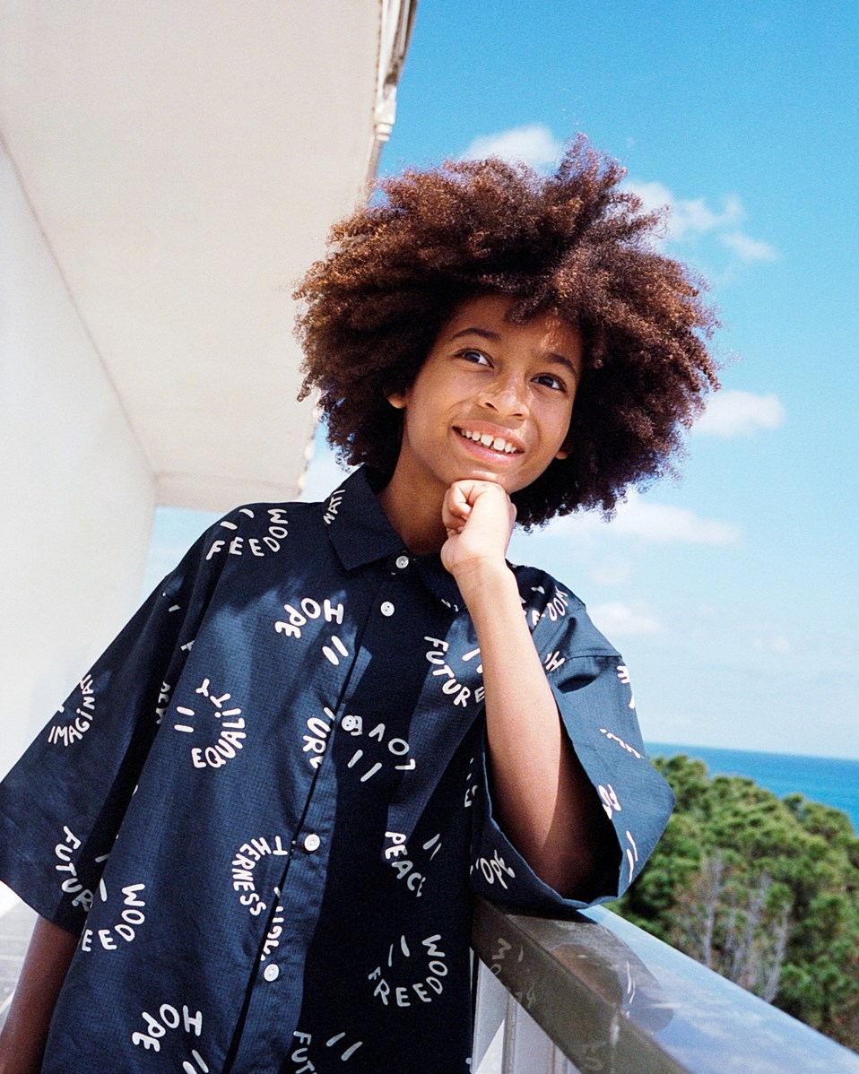 Richie - Smile Words - Dunkelblaues Shirt mit Aufdruck für Kinder aus weicher Öko-Baumwolle mit weiten T-Shirt-Ärmeln, klassischem Hemdkragen und Knopfverschluss auf der Vorderseite.
