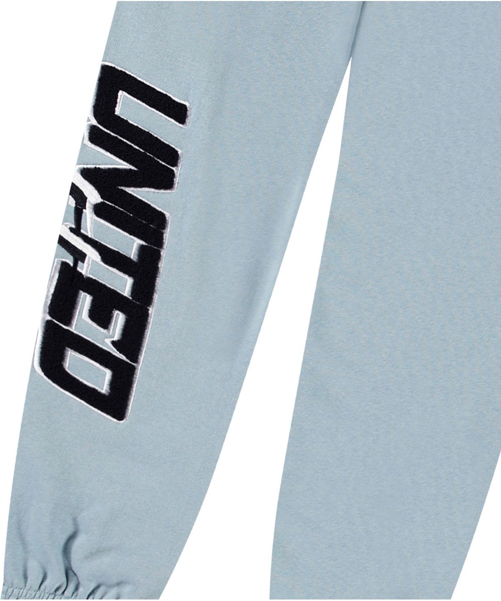 Allen - Misty Blue - Hellblaue Öko-Baumwollhose mit 'United Future'-Aufdruck für Kinder.