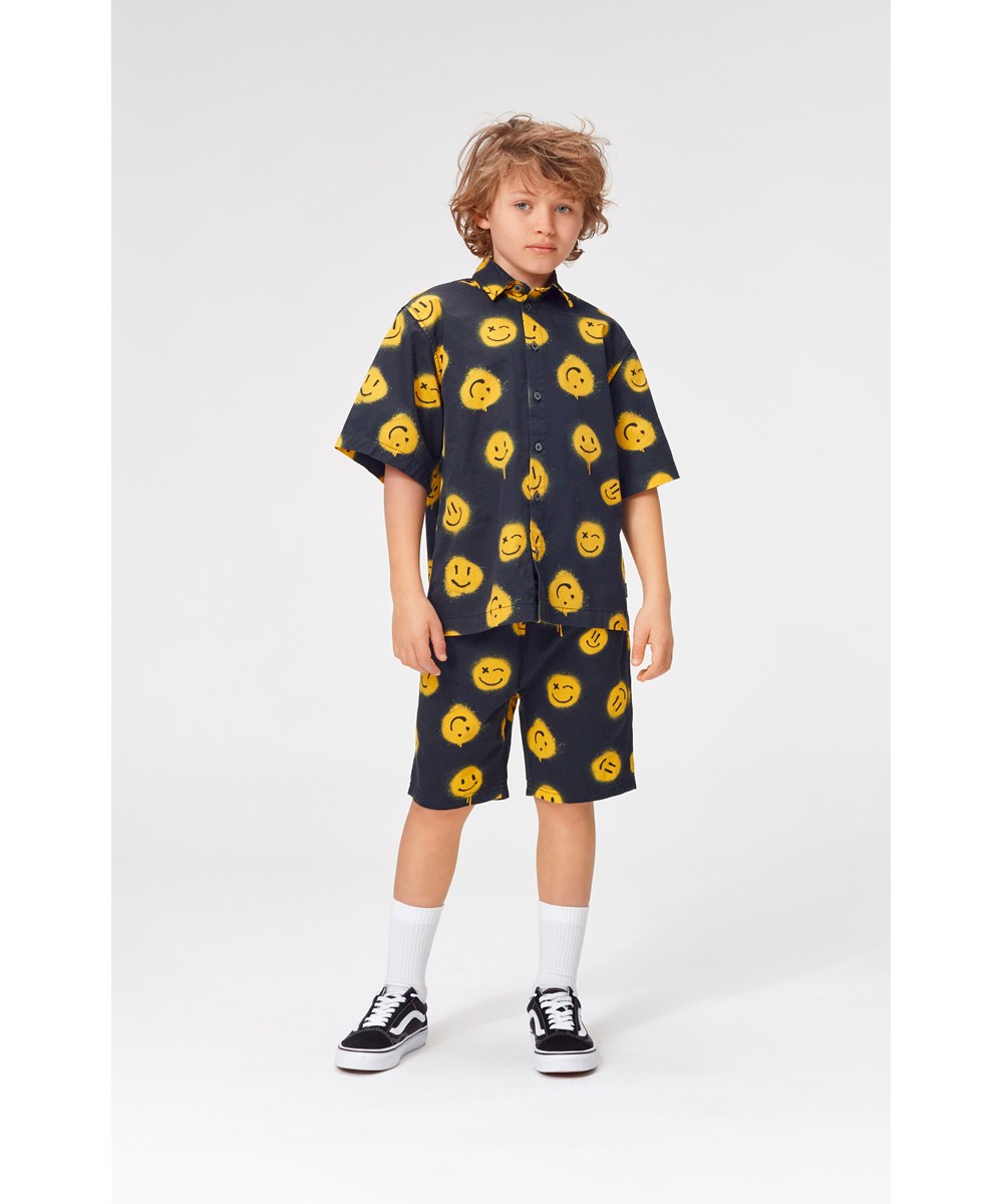 Avart - Smiles - Schwarze Shorts mit gelben Graffiti-Smileys.