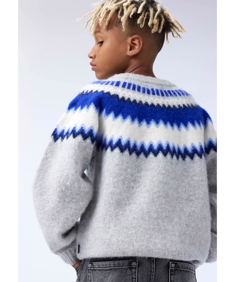 Baes wool - Nordic Blues - Hellgrauer Strickpullover für Kinder aus Wolle mit einem blauen, von der nordischen Tradition inspirierten Muster.