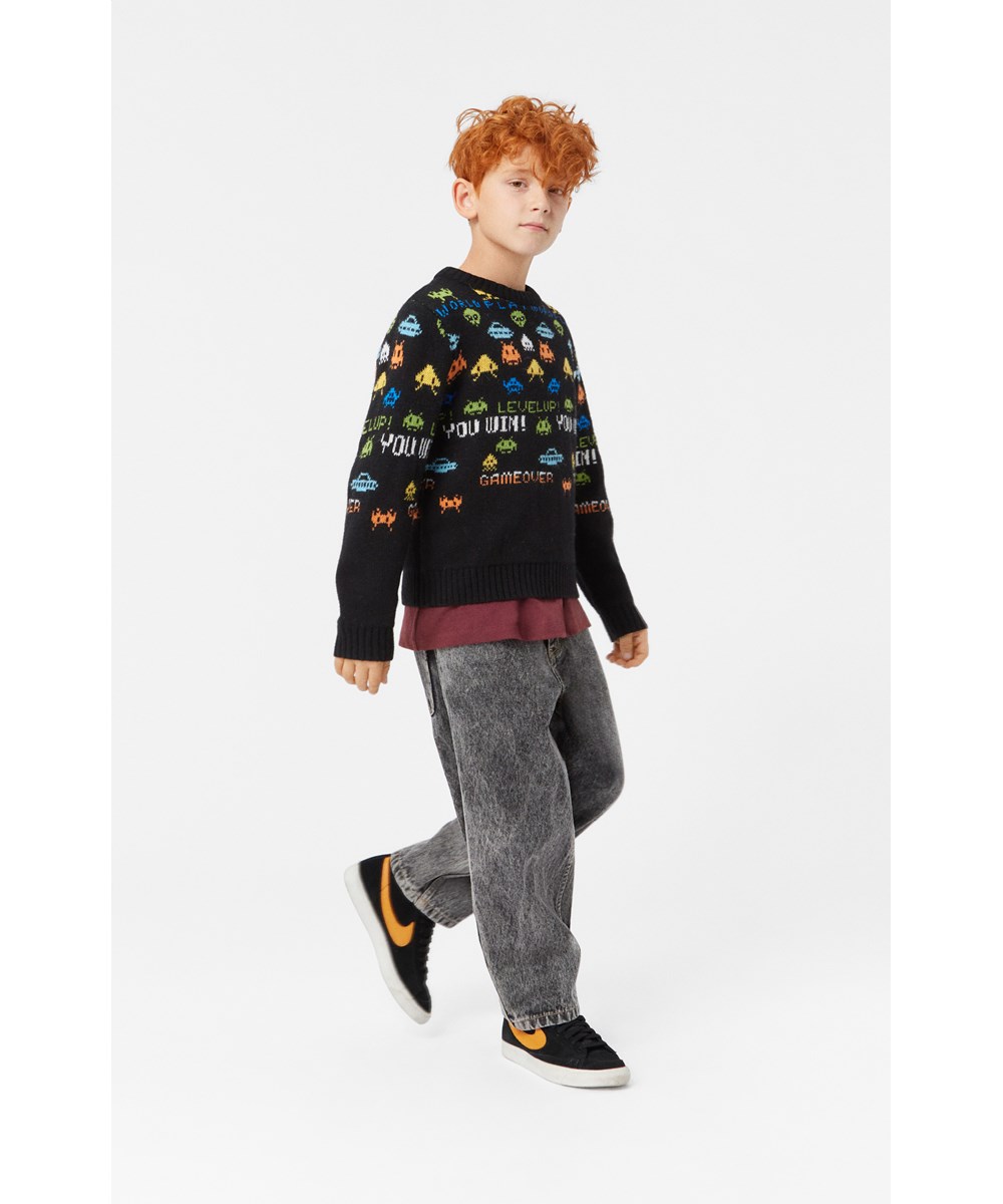 Barri - Level Up! - Schwarzer Pullover mit langen Ärmeln und mehrfarbigem Pixel-inspiriertem Muster.