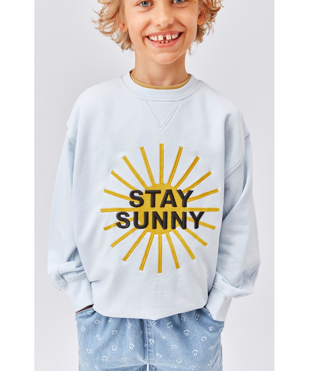 Magni - Iced Blue - Hellblaues Sweatshirt mit Stay Sunny Sonne-Stickerei