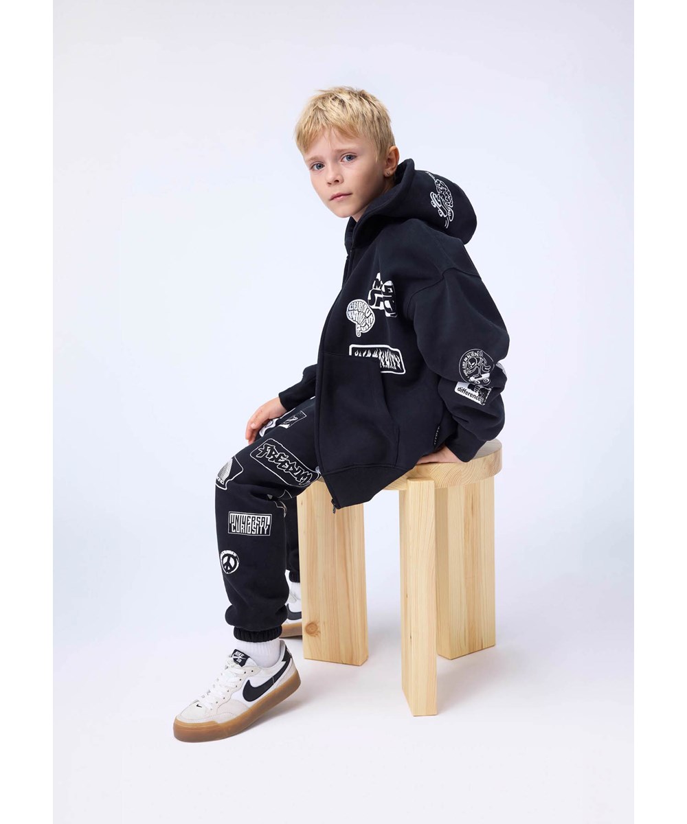 Marley - Black - Schwarzer Kapuzenpullover mit Reißverschluss für Kinder aus Baumwolle mit weißem Aufdruck.
