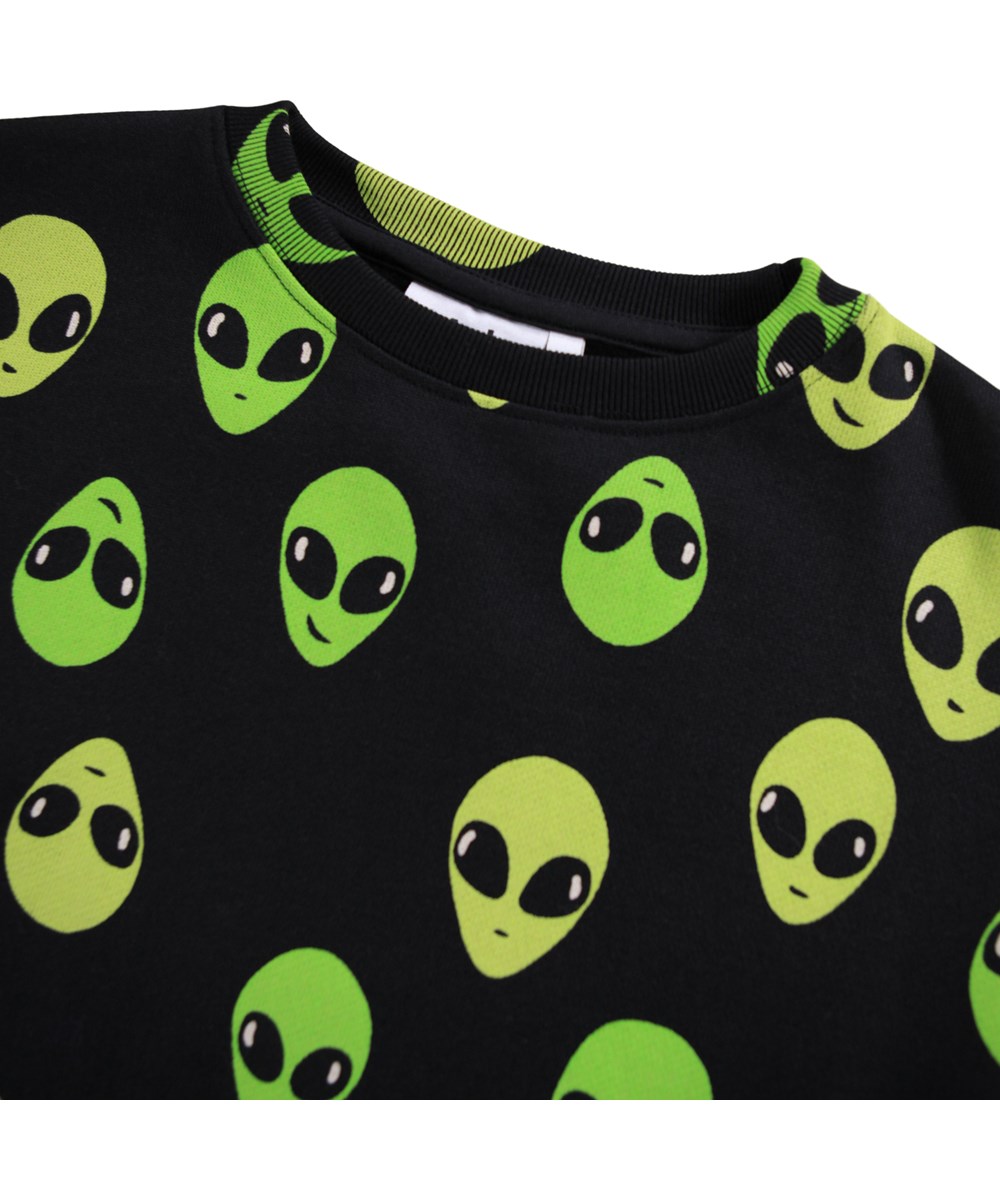 Monti - Alien Faces - Schwarzer Pullover für Kinder aus weicher Öko-Baumwolle mit einem Alien-Druck.