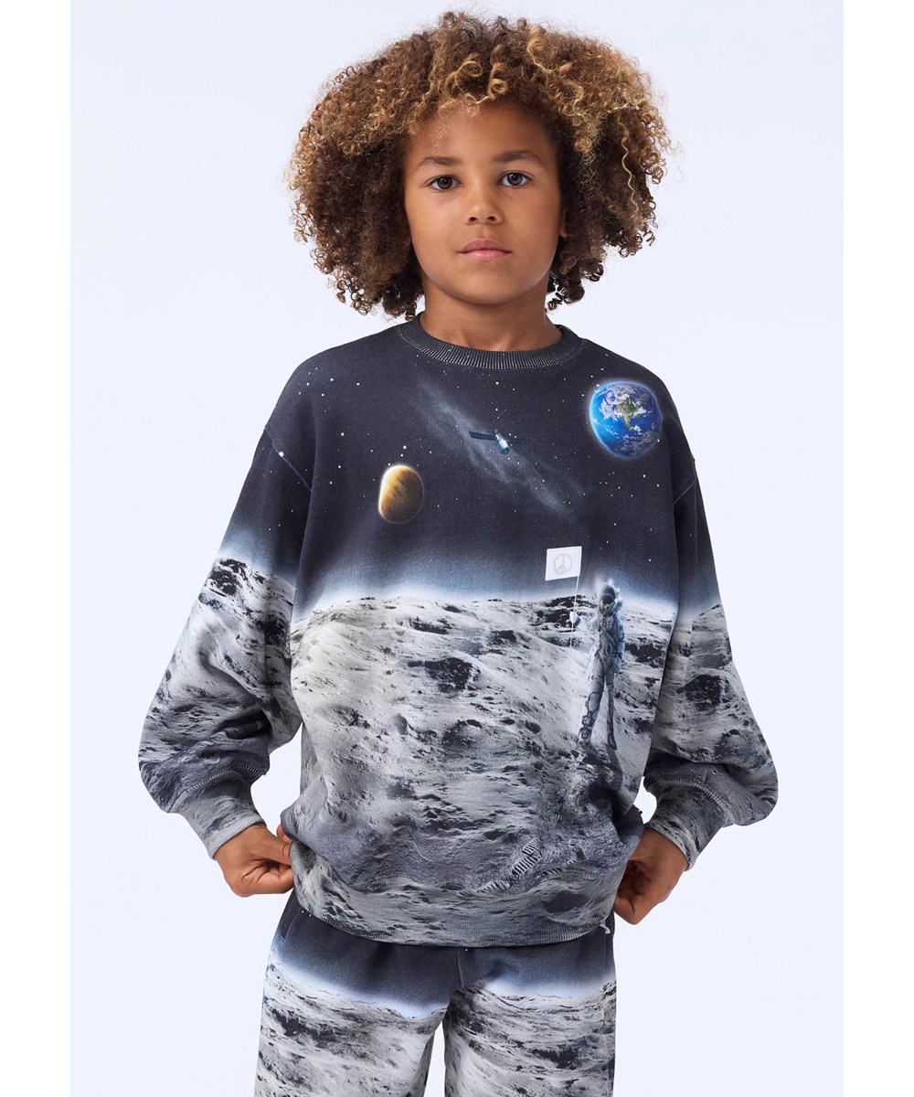Monti - Moon Traveller - Sweatshirt aus weicher Öko-Baumwolle für Kinder mit einem Aufdruck eines Astronauten auf dem Mond.