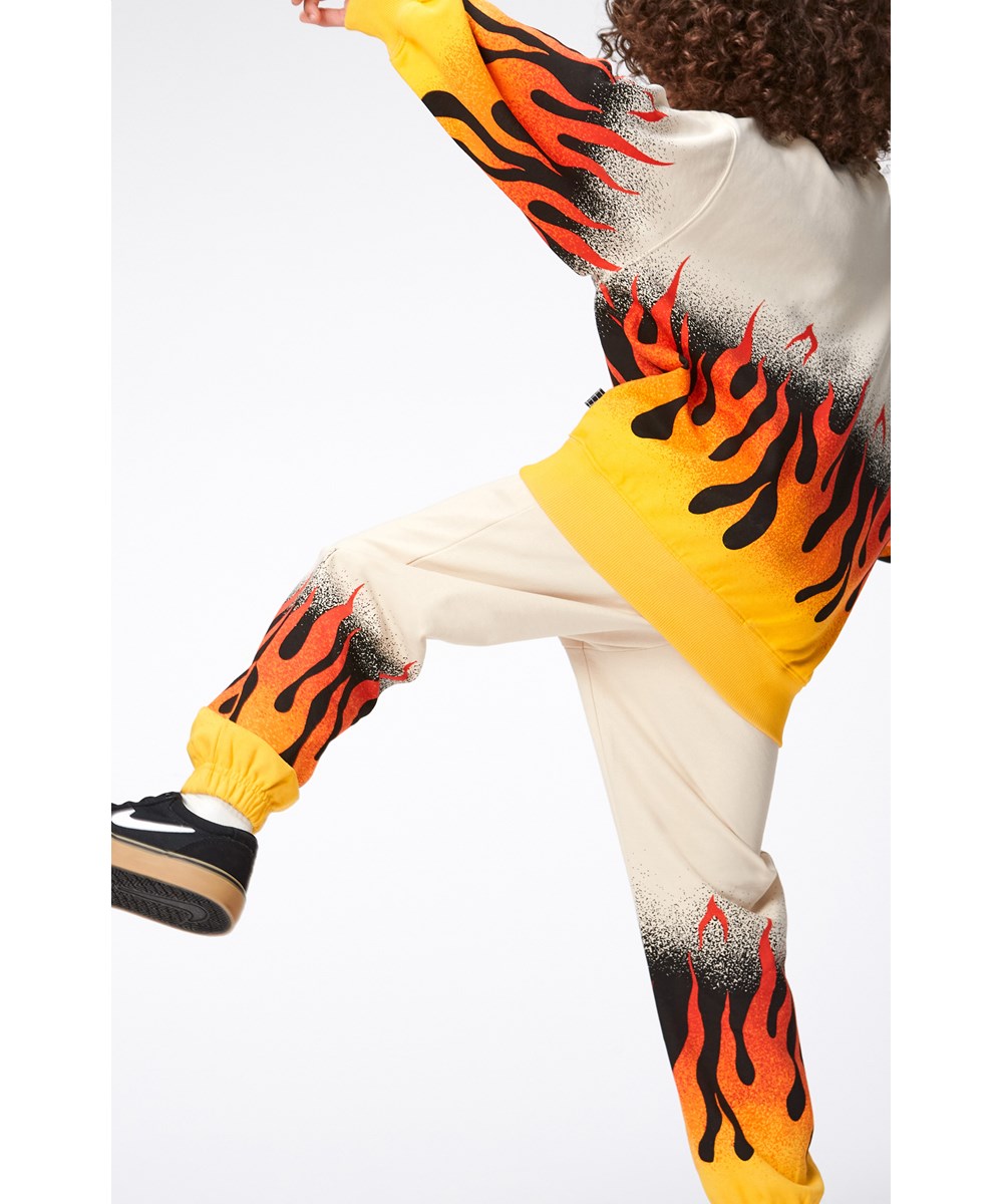 Monti - On Fire - Beiges Öko-Sweatshirt mit orangefarbenem Flammendruck