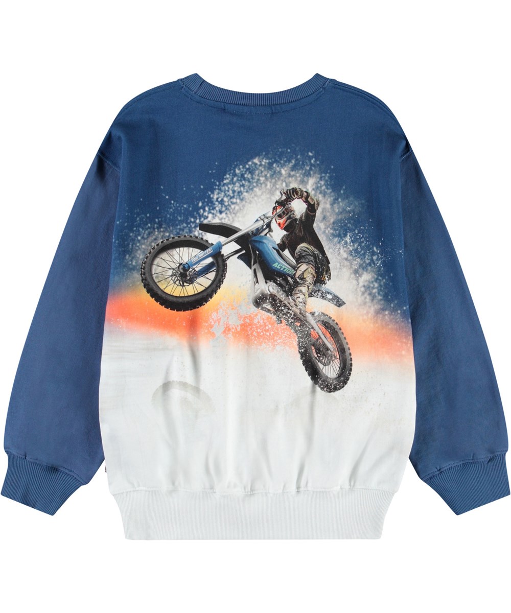 Monti - Wheelie Blue - Blauer und weißer Pullover mit Druck für Kinder aus weicher, organischer Baumwolle mit gerippten Kanten am Hals, an den Ärmeln und am unteren Saum des Pullovers.