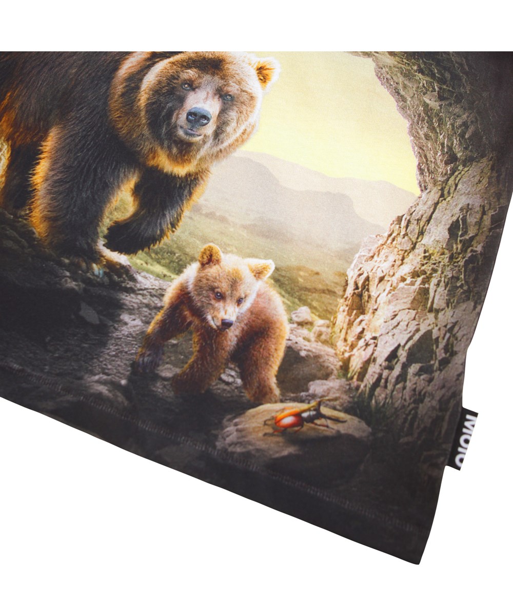 Riley - Cave Bears - Dunkelbraunes T-Shirt für Kinder aus weicher Öko-Baumwolle mit einem Aufdruck, kurzen Ärmeln und einem gerippten Ausschnitt.