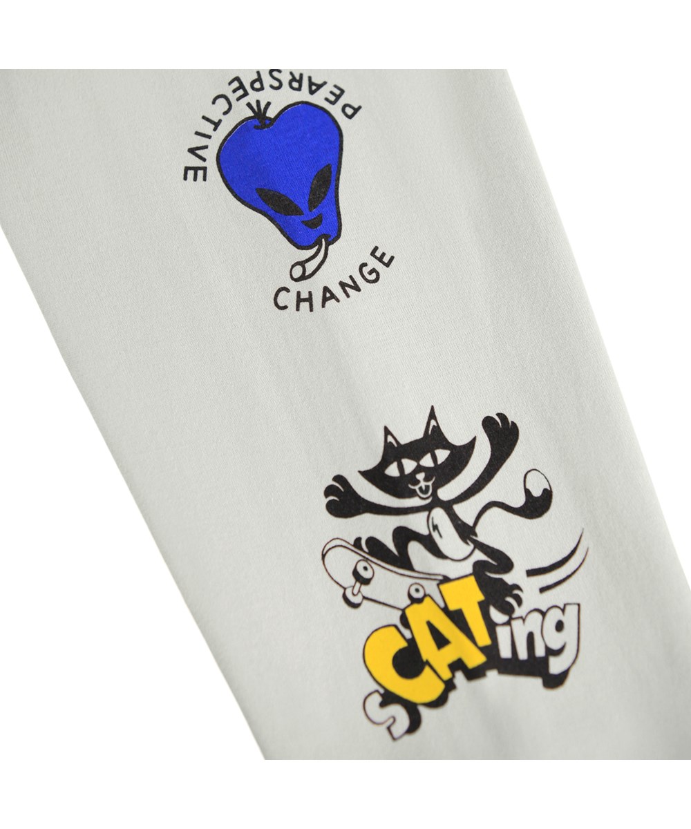 Rube - Comic Skate - Beiges Langarmshirt für Kinder aus Öko-Baumwolle mit geripptem Ausschnitt und Ärmeln, bedruckt mit Aliens und Katzen auf Skateboards sowie lustigen und niedlichen Sprüchen entlang der Ärmel.