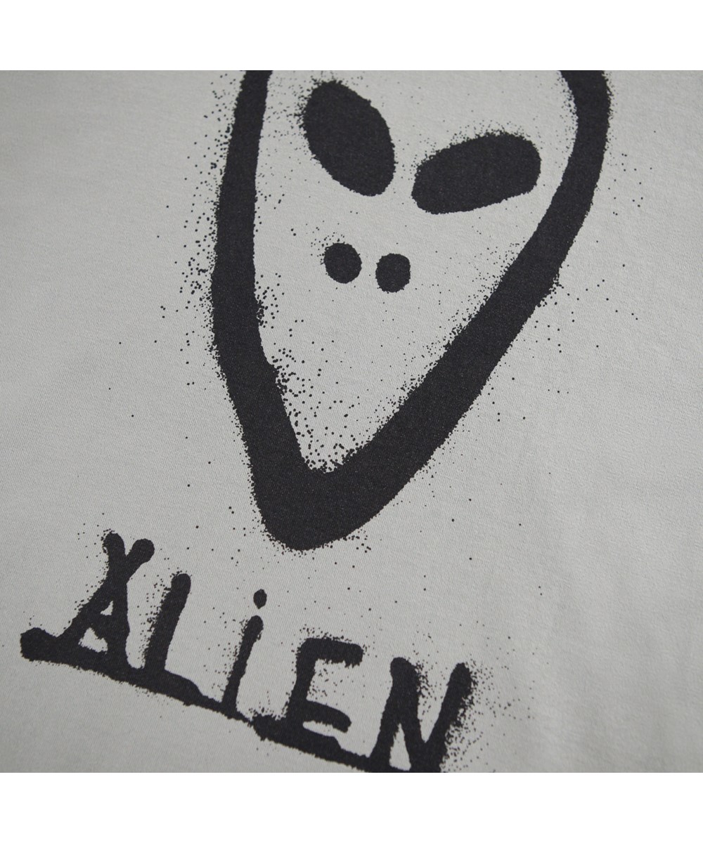 Rube - Forest Fog - Khakifarbenes Langarmshirt für Kinder aus Öko-Baumwolle mit geripptem Ausschnitt und einem grafisch bemalten Alien-Gesicht auf Vorder- und Rückseite.