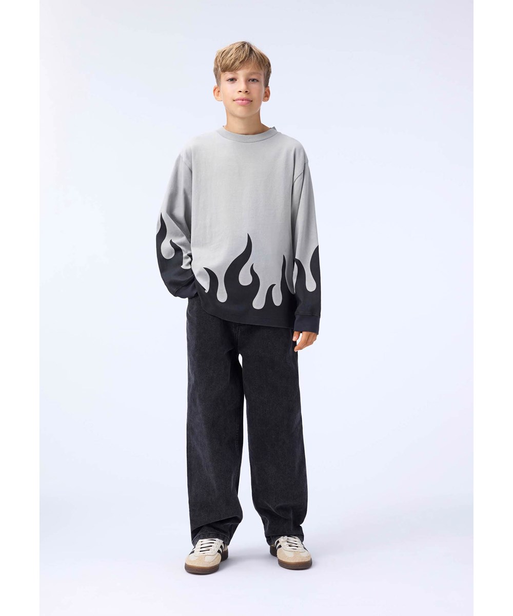Rube - Heated - Graues Langarmshirt für Kinder aus Öko-Baumwolle mit geripptem Ausschnitt und Ärmeln sowie einem schwarzen Flammenmuster an der Taille.