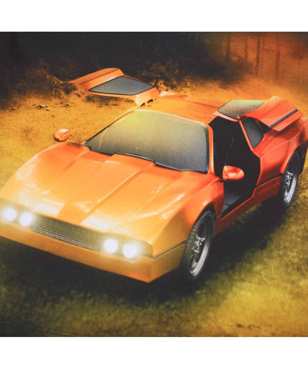 Rube - Red Car - Schwarzes Langarmshirt für Kinder aus Öko-Baumwolle mit geripptem Ausschnitt und einem Frontdruck eines roten Sportwagens in einem dunklen Wald.