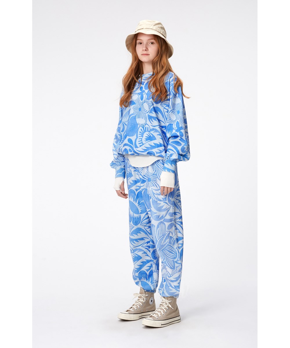 Adan - Charleston Blue - Hellblaue Hose aus Öko-Baumwolle mit einem Aufdruck aus kunstvollen Blumen