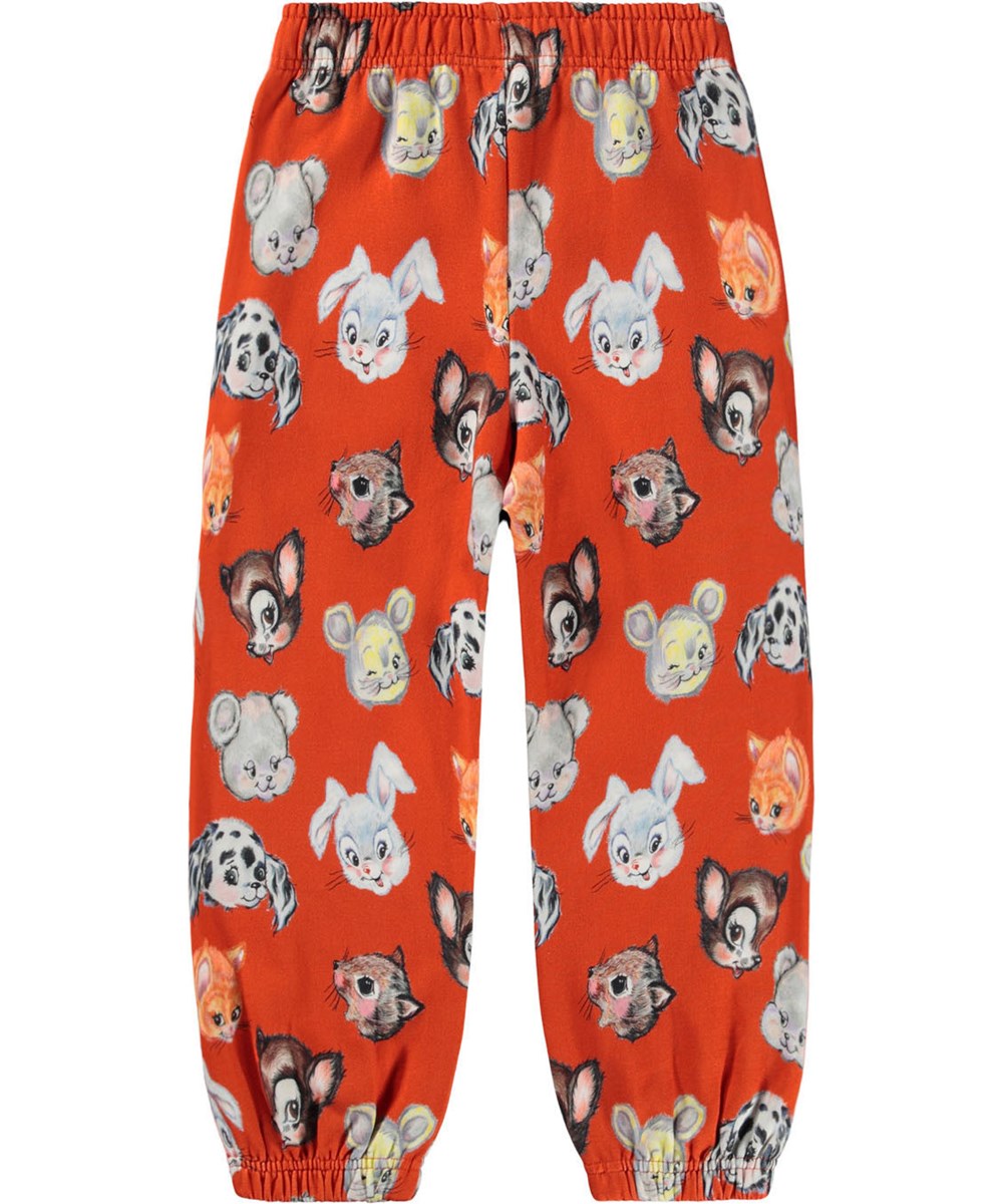 Adan - Rising Sun - Orange Jogginghosen für Kinder aus Öko-Baumwolle mit einem Aufdruck von niedlich gezeichneten Tieren.