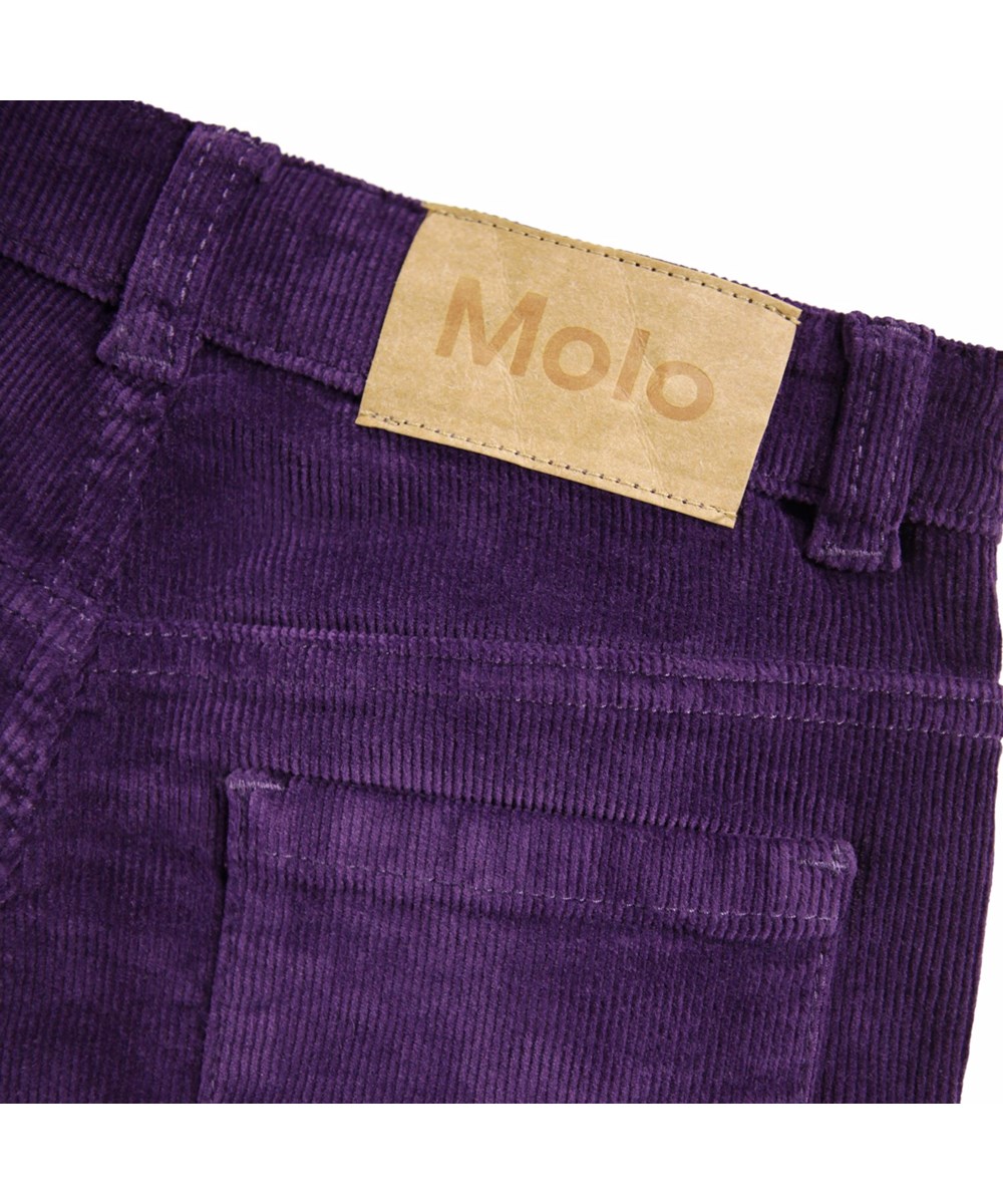 Aida - Space Purple - Lila Hosen für Kinder aus weichem Baumwoll-Velvet in einer trompetenförmigen Silhouette.
