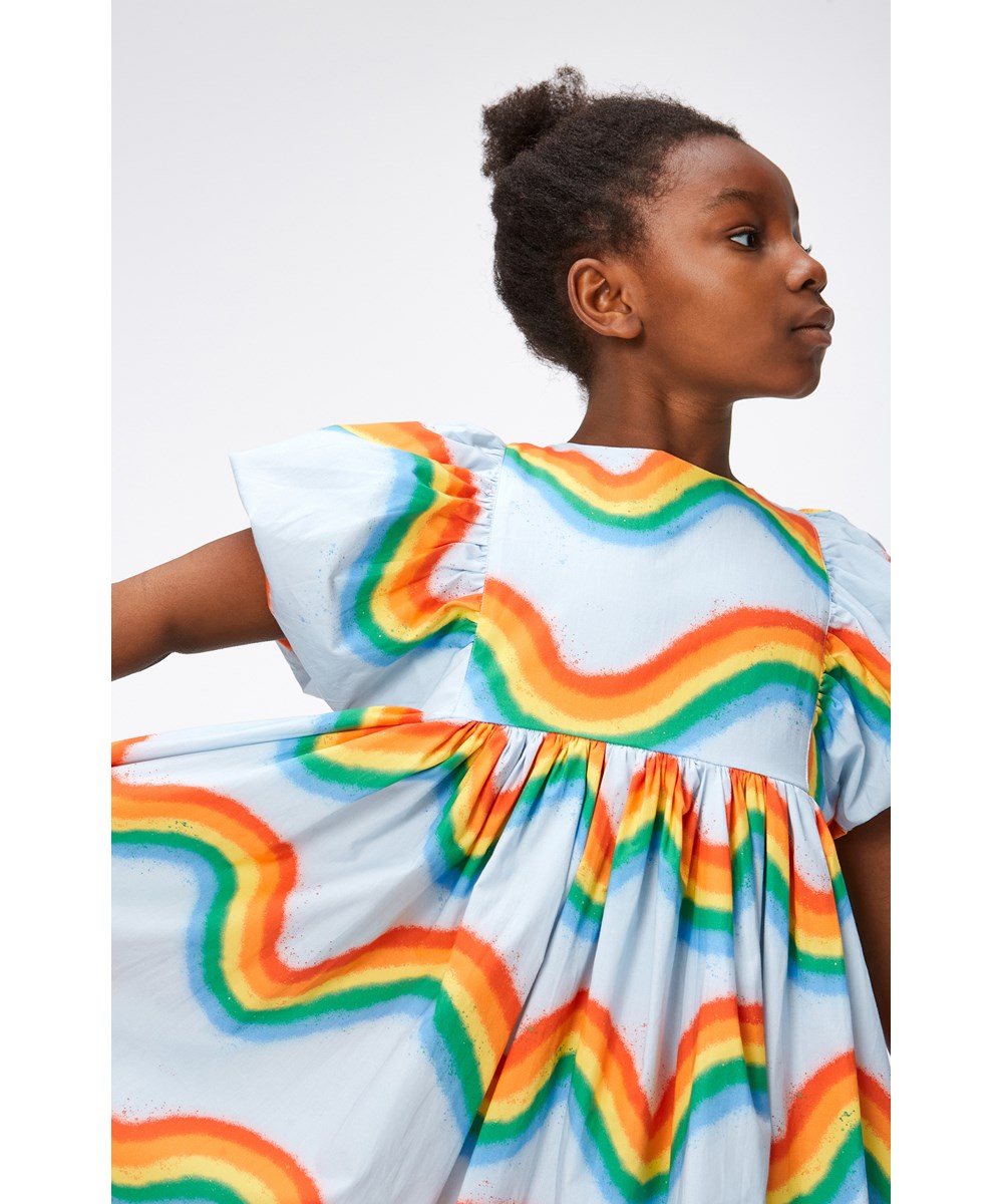 Calyita - Rainbow Waves - Hellblaues Kleid aus Öko-Baumwolle mit Regenbogendruck