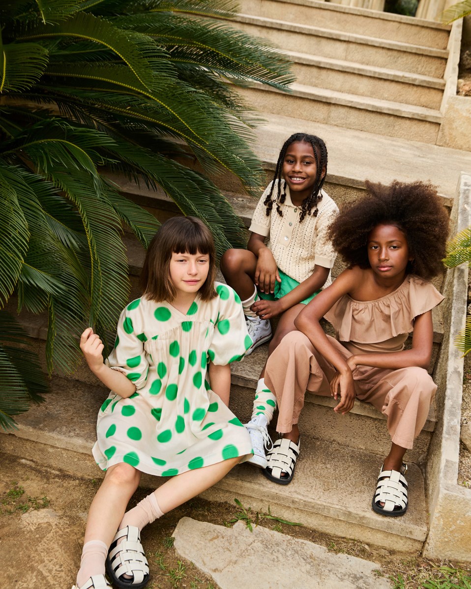 Camellia - Green Dots - Beiges Kleid für Kinder aus Viskose mit einem V-Ausschnitt und großen grünen Punkten.