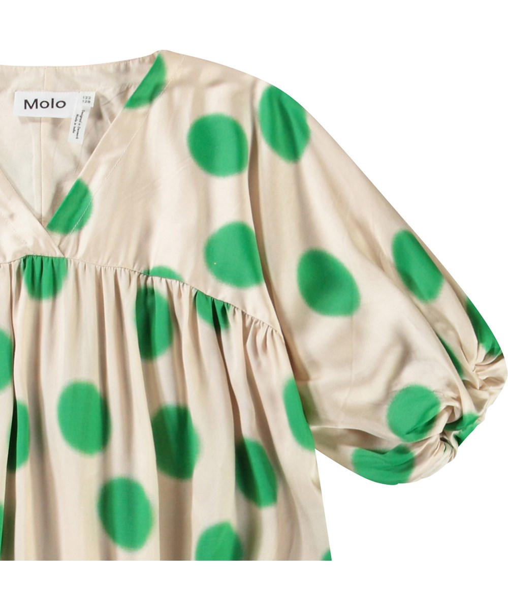 Camellia - Green Dots - Beiges Kleid für Kinder aus Viskose mit einem V-Ausschnitt und großen grünen Punkten.