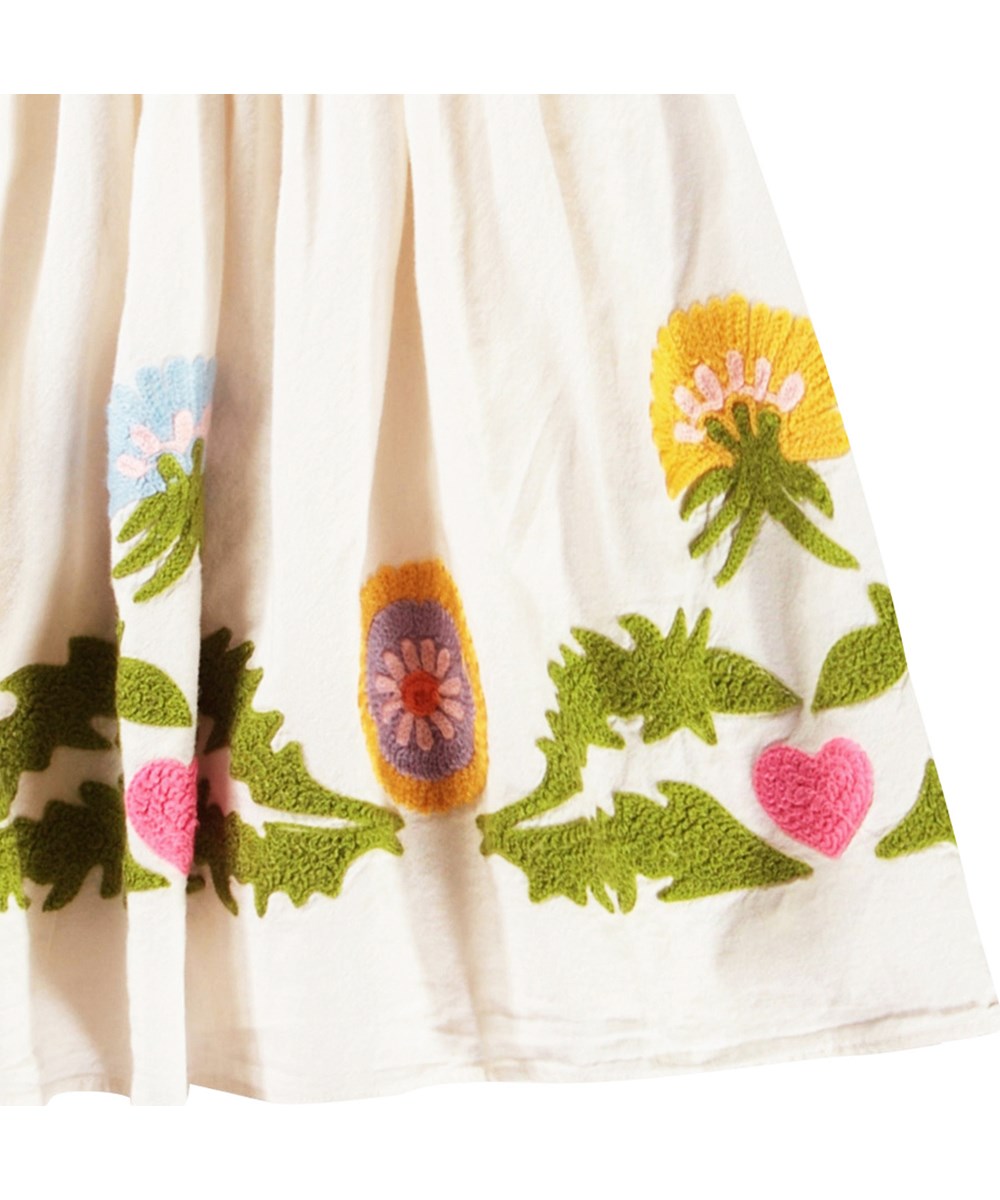 Carlin - Dandelion Border - Knielanges, cremefarbenes Kleid für Kinder aus weicher Baumwolle mit einem runden Ausschnitt und Schmetterlingsärmeln.