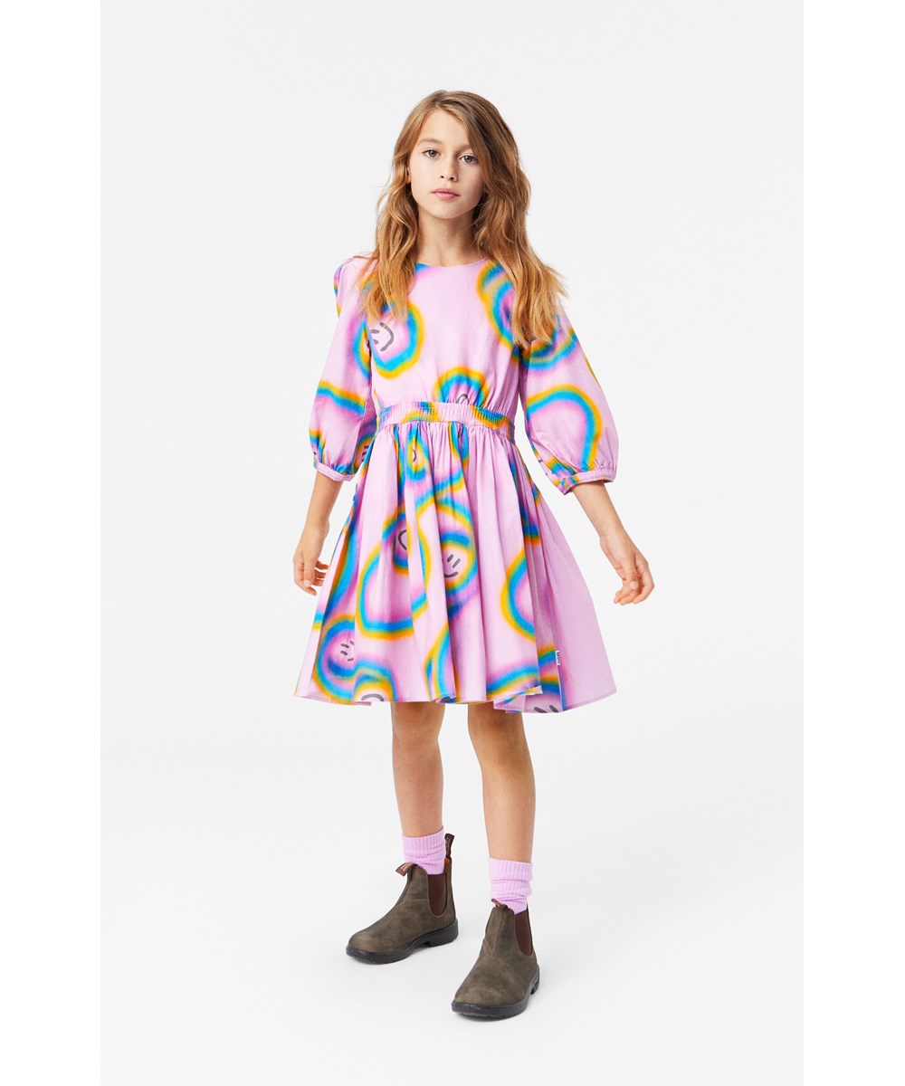 Choly - Accelerating Smiles - Rosa knielanges Kleid aus Öko-Baumwolle mit schwebendem Regenbogenmuster.