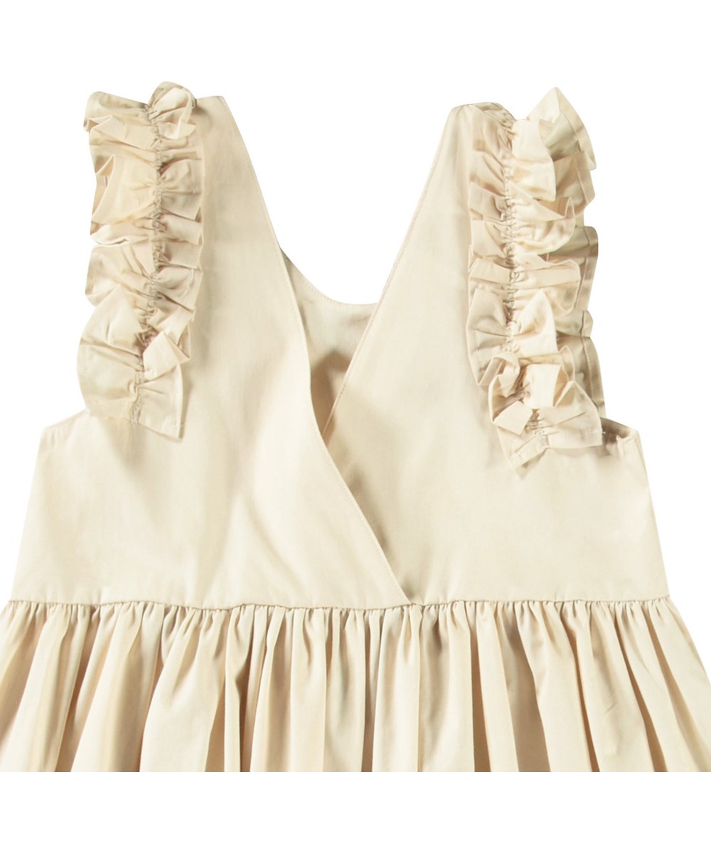 Cicely - Horse Border - Beiges knielanges Kleid für Kinder aus Öko-Baumwolle mit Rüschenbesatz an den Ärmelausschnitten.