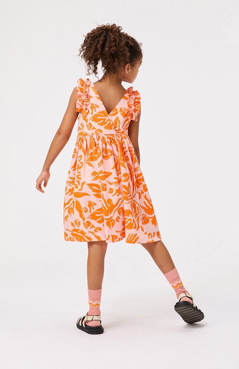 Cicely - Peachy Nature - Leichtes orangefarbenes knielanges Kleid für Kinder aus Öko-Baumwolle mit Rüschenbesatz an den Ärmelausschnitten.