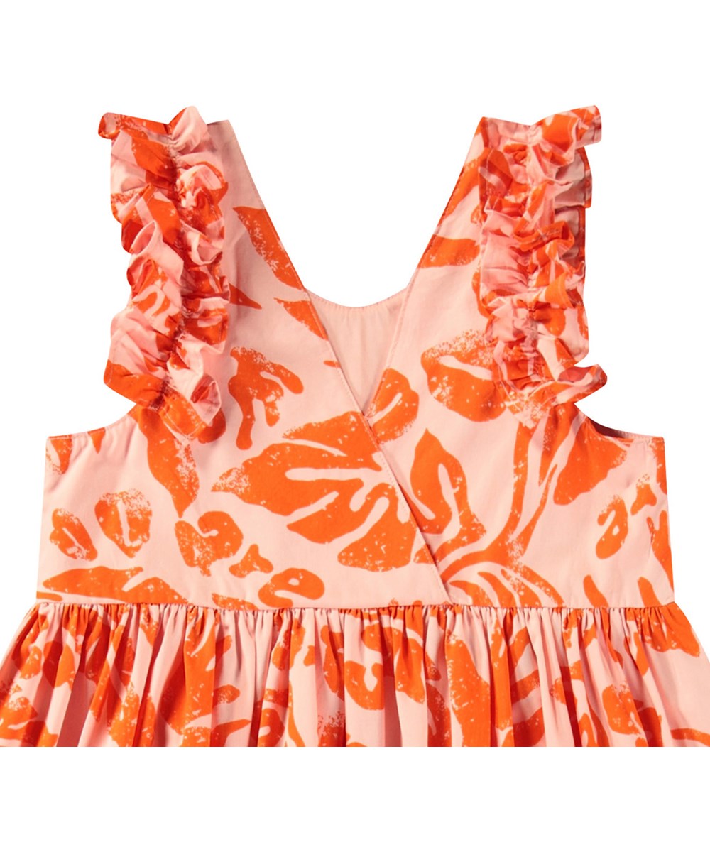 Cicely - Peachy Nature - Leichtes orangefarbenes knielanges Kleid für Kinder aus Öko-Baumwolle mit Rüschenbesatz an den Ärmelausschnitten.