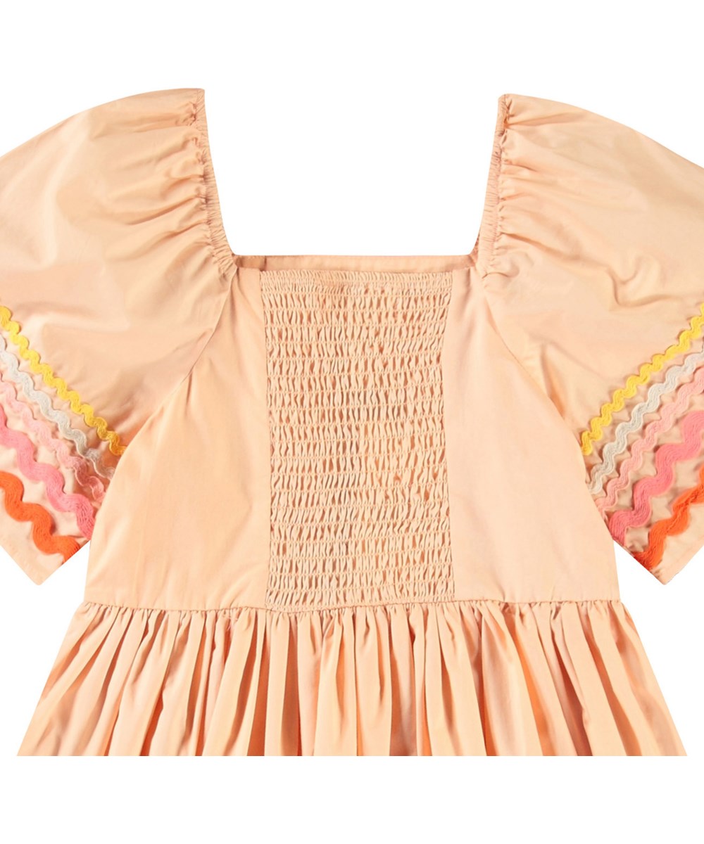 Clotilde - Pale Melon - Knielanges orangefarbenes Kleid für Kinder aus Öko-Baumwolle mit weiten Schmetterlingsärmeln.