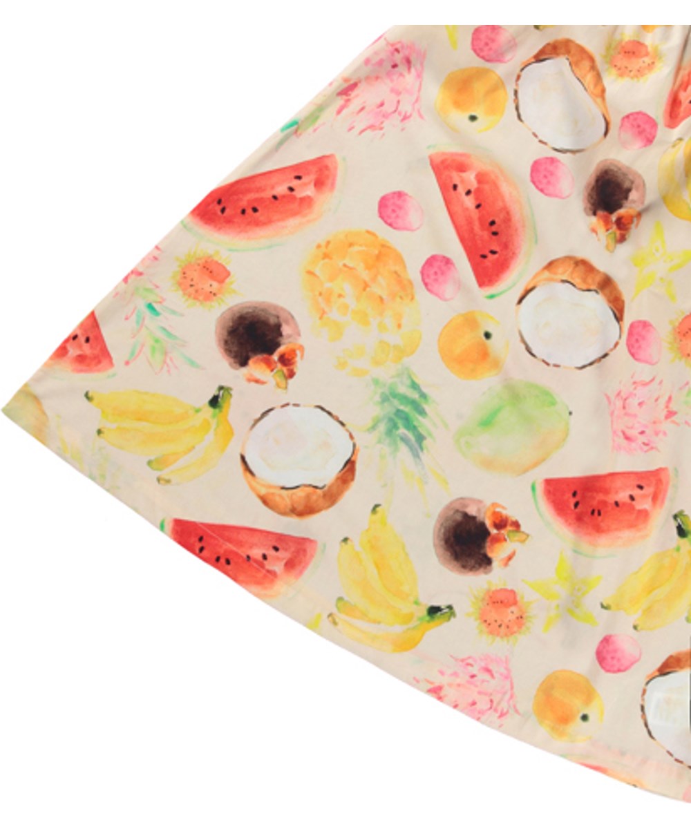 Connie - Painted Fruits - Beiges lockeres Kleid für Kinder aus Öko-Baumwolle mit einem Druck von bunten exotischen Früchten, dünnen Trägern und gerüschtem Saum.