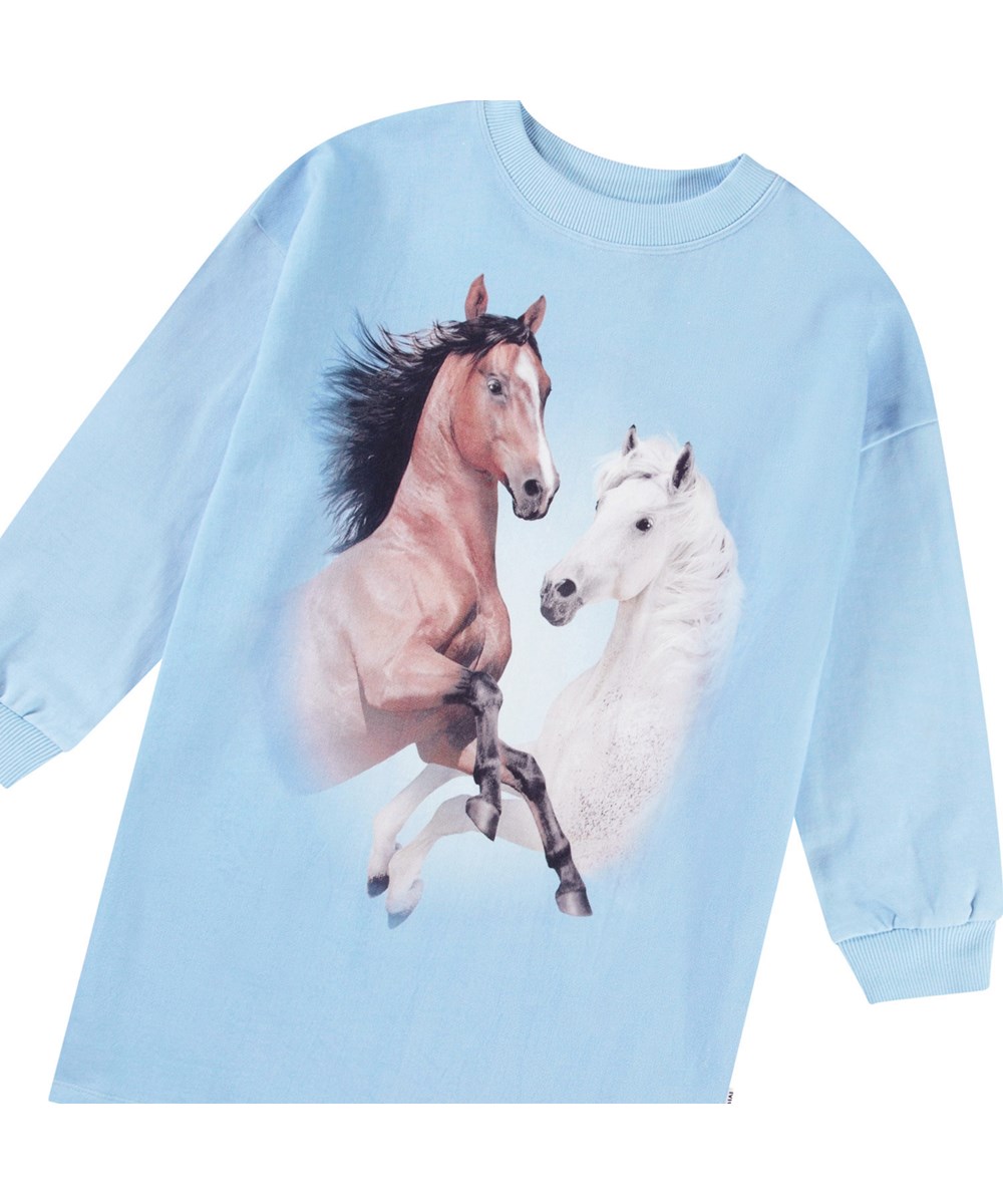 Cyrella - Bleu Horses - Hellblaues Trikotkleid für Kinder aus weicher Öko-Baumwolle mit gerippten Kanten an den Ärmeln und am Ausschnitt.