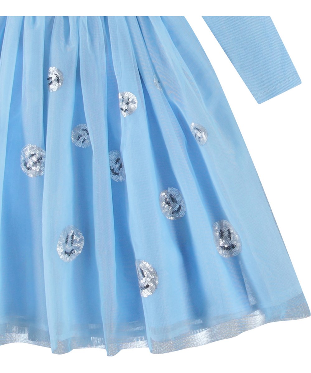Cyrus - Day Sky - Hellblaues langärmeliges Kleid für Kinder mit hellblauem Tüllrock und lächelnden Pailletten-Gesichtern.
