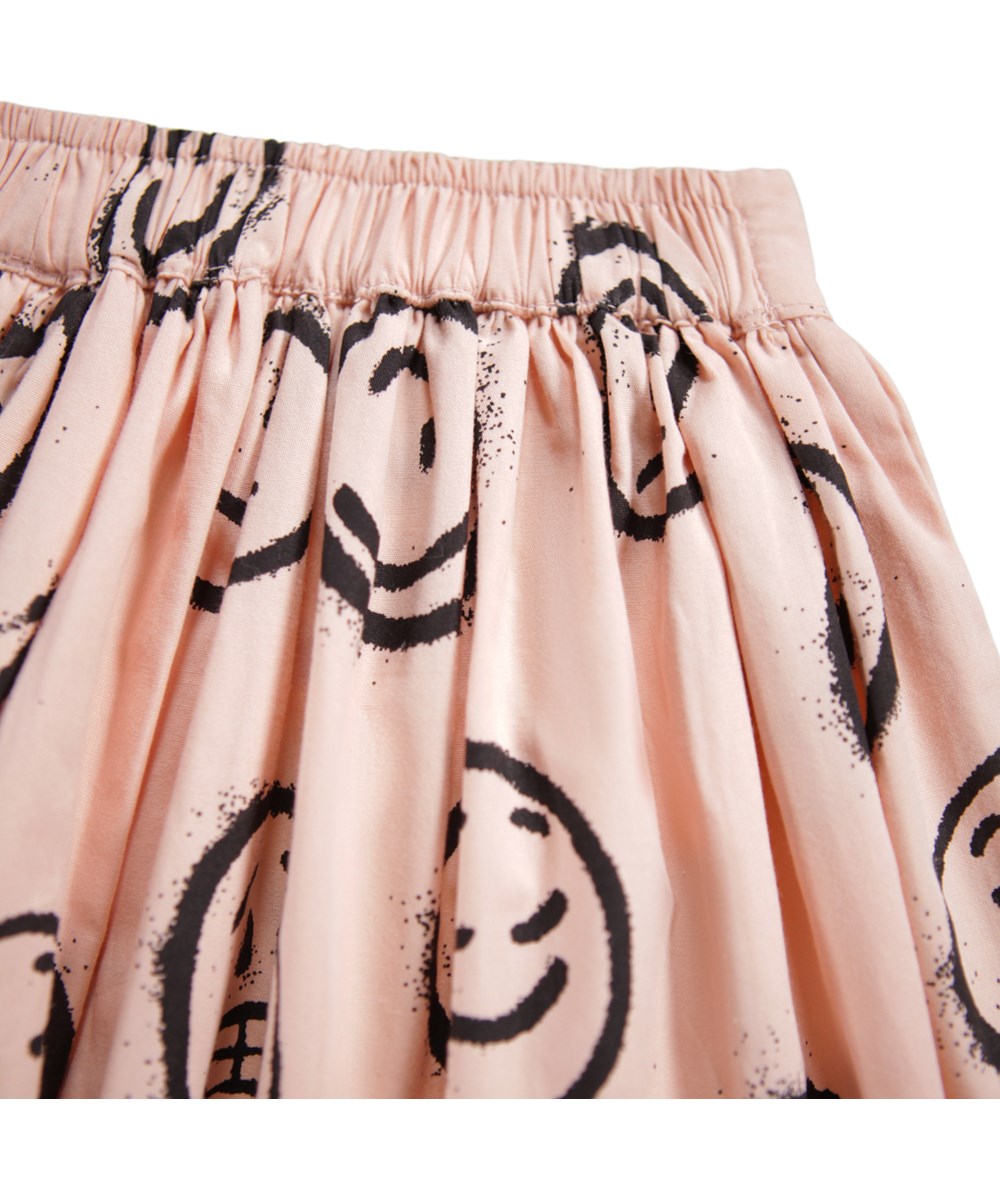 Bonnie - Rose Cloud Moods - Rosa knielanger Rock für Kinder aus Öko-Baumwolle mit einem Aufdruck von Gesichtern in verschiedenen Stimmungen.