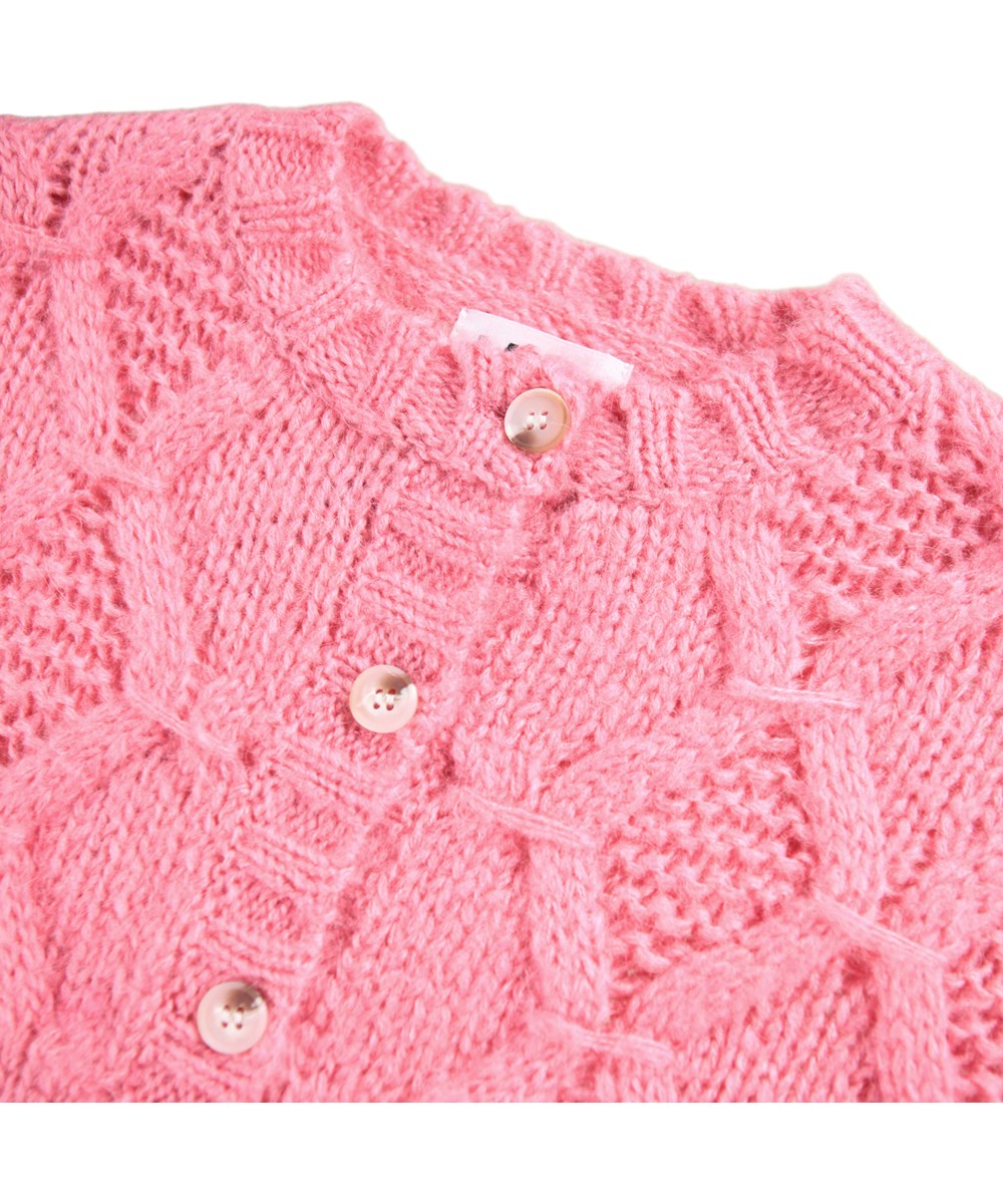 Gracelyn - Confetti - Dicke rosa Strickjacke aus einer Alpakawollmischung. Diese Strickjacke hat ein wunderschönes gewebtes Muster, voluminöse Ballonärmel und feine Knöpfe vorne. Die Strickjacke hat gerippte Kanten am Halsausschnitt, an den Ärmeln und am Saum.