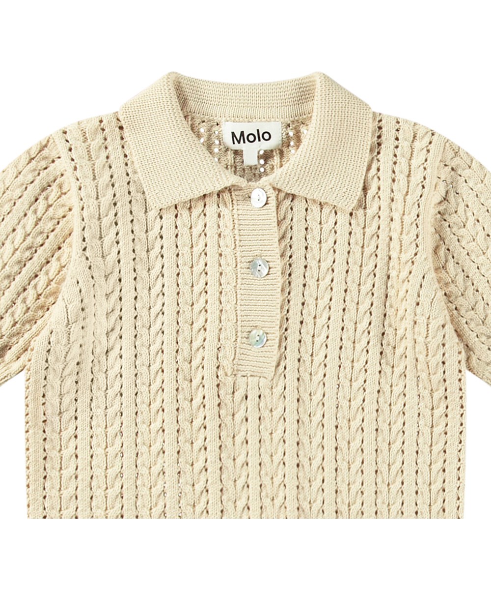 Gretel - Brazilian Sand - Gestricktes cremefarbenes T-Shirt für Kinder aus weicher Öko-Baumwolle mit Perlmuttknöpfen.