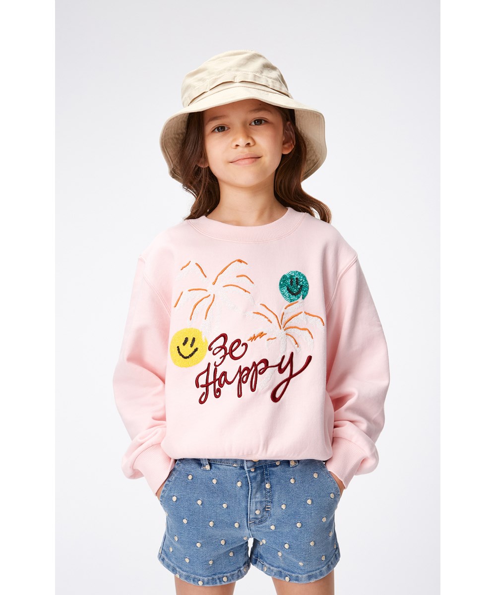 Marge - Glitter Palms - Rosafarbenes Sweatshirt aus Öko-Baumwolle mit zwei kleinen Paillettenstickereien mit lächelnden Gesichtern, Palmenaufdruck und dem Text „Be Happy“ auf der Vorderseite