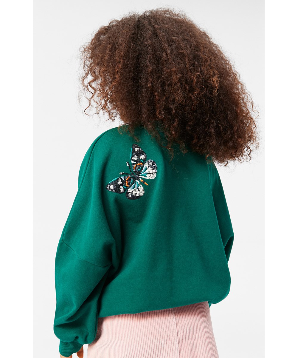 Marika - Aventurine - Flaschengrünes Sweatshirt aus weicher Öko-Baumwolle mit mehrfarbigen Paillettenstickereien von Schmetterlingen.
