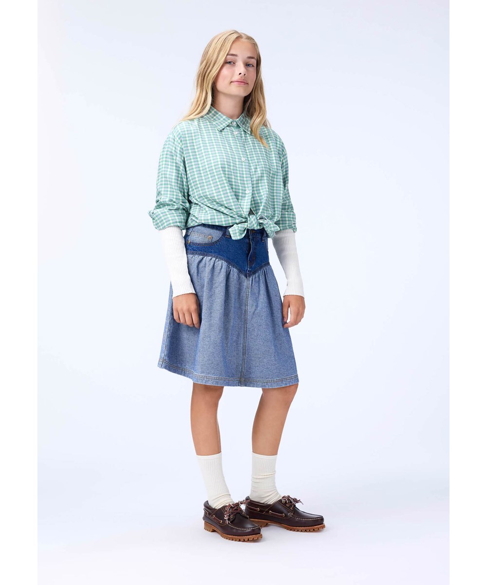 Rochelle - Buttercream - Off-weißes Langarm-Oberteil für Kinder aus elastischem, biologischem Baumwollripp mit einer eng anliegenden Passform, einem Rundhalsausschnitt und rohen Kanten an beiden Ärmeln mit Daumenlöchern.