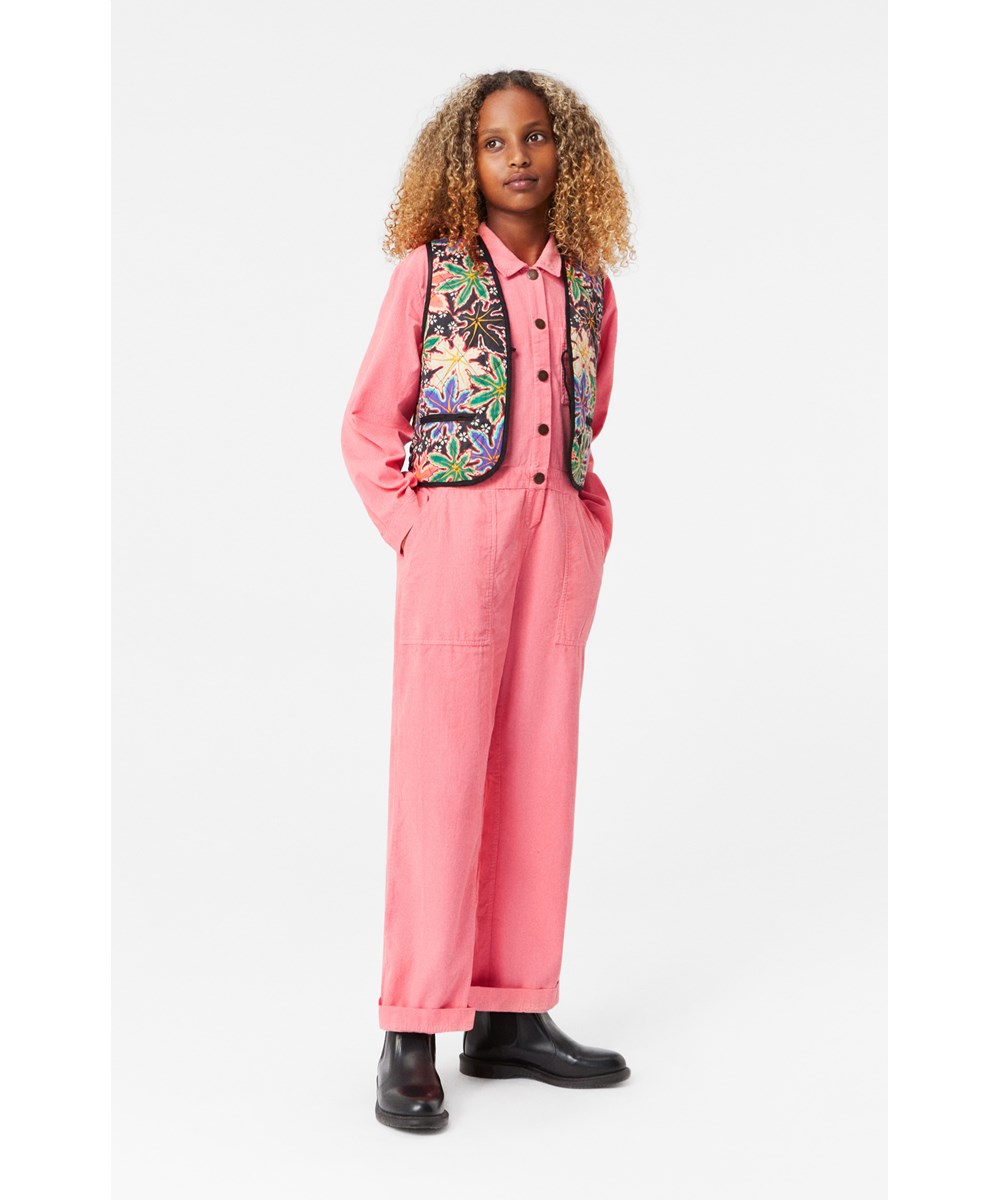 Angie - Flamingo Plume - Koraalrode ribfluwelen jumpsuit met wijde pijpen en grote zakken.