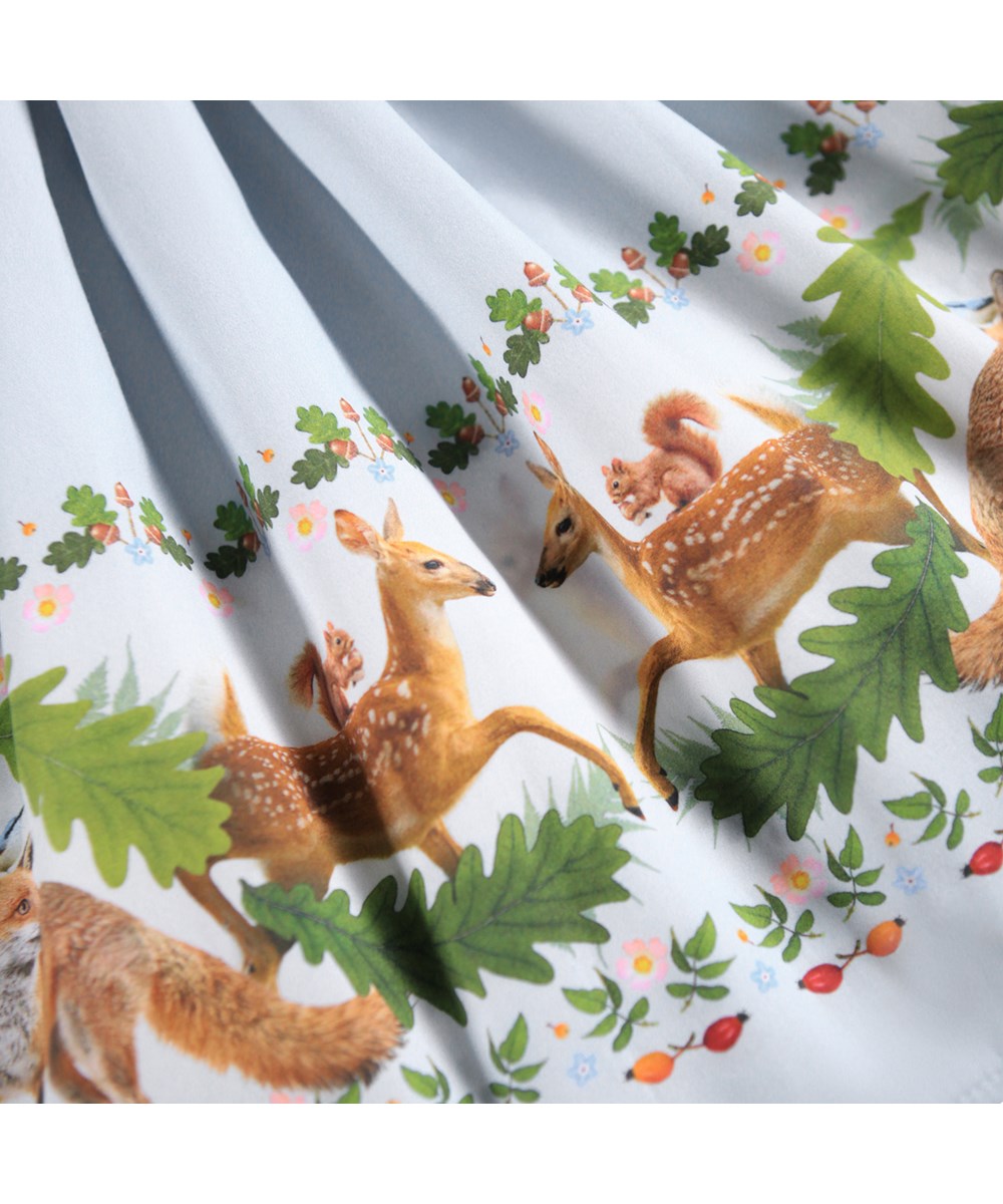 Casie - Forest Border - Lange lichtblauwe kinderjurk gemaakt van biologisch katoen met lange mouwen, een popeline rok en een print van dieren in het bos.