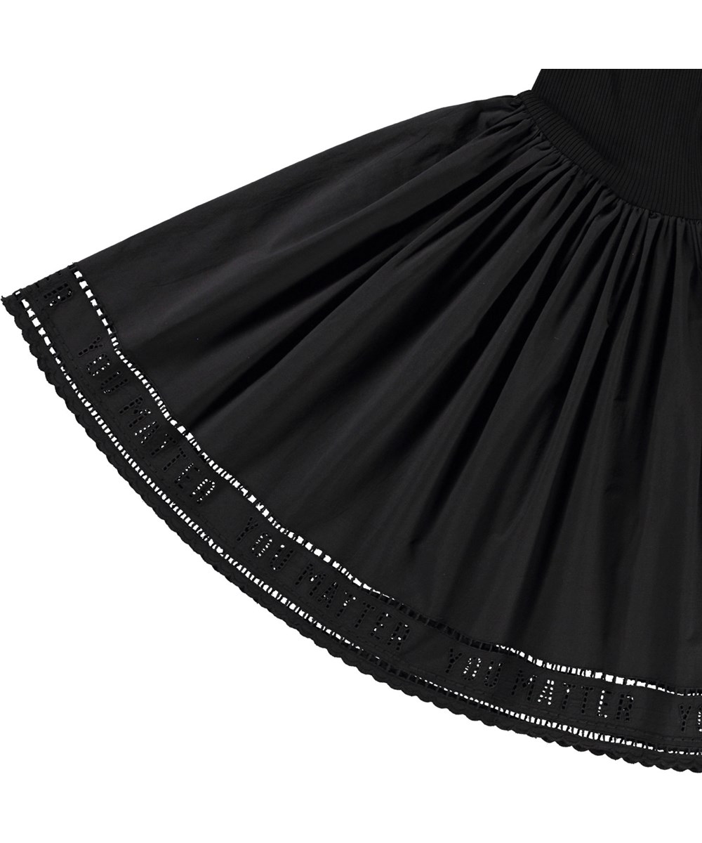 Cibelle - Black - Zwarte kinderjurk van biologisch katoen met lange mouwen, een aansluitende jerseyrib top, ronde hals en een volumineuze cirkelrok van poplin katoen.