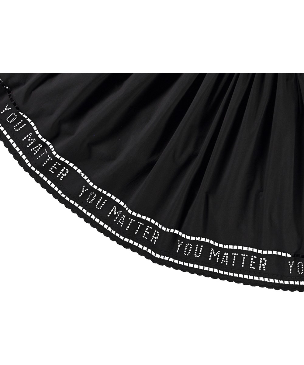 Cibelle - Black - Zwarte kinderjurk van biologisch katoen met lange mouwen, een aansluitende jerseyrib top, ronde hals en een volumineuze cirkelrok van poplin katoen.