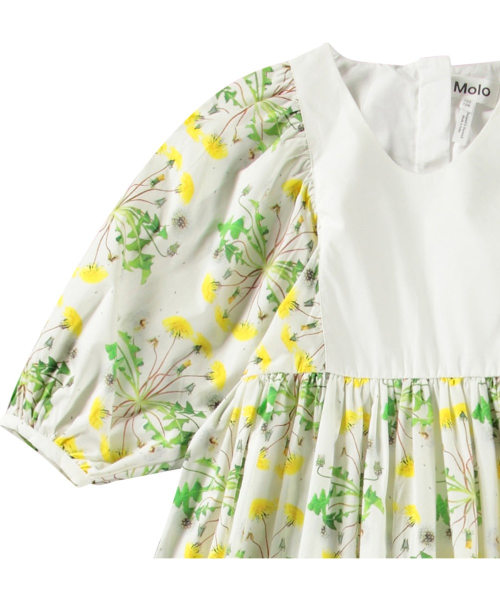 Cinzia - Dandelion Dotty - Witte kinderjurk van biologisch katoen met ronde hals en pofmouwen met een knoopje.