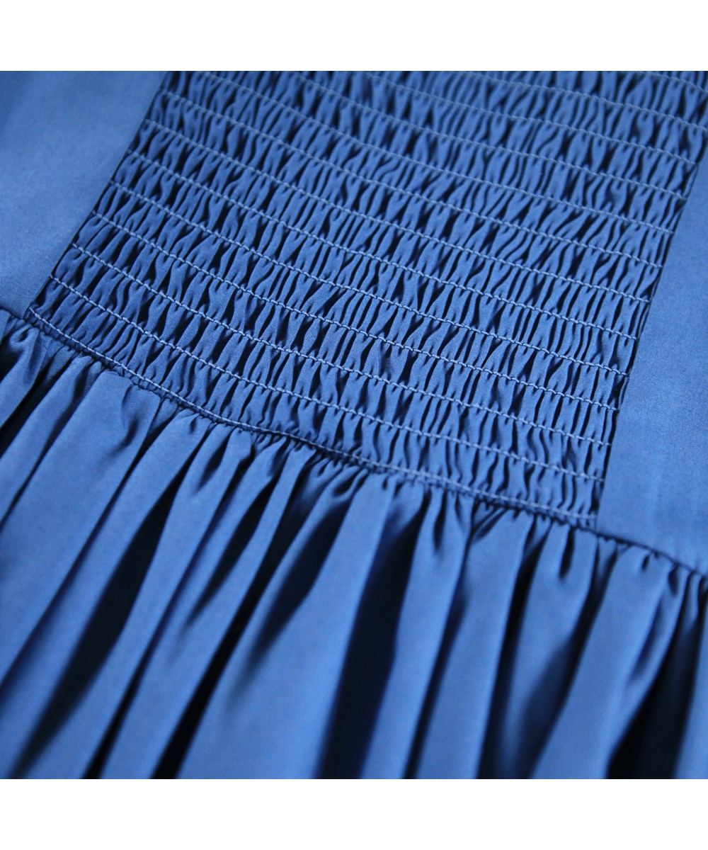 Ciris - Mystic Blue - Blauwe kinderjurk gemaakt van biologisch katoen met kleurrijke zigzaglinten als leuk detail.